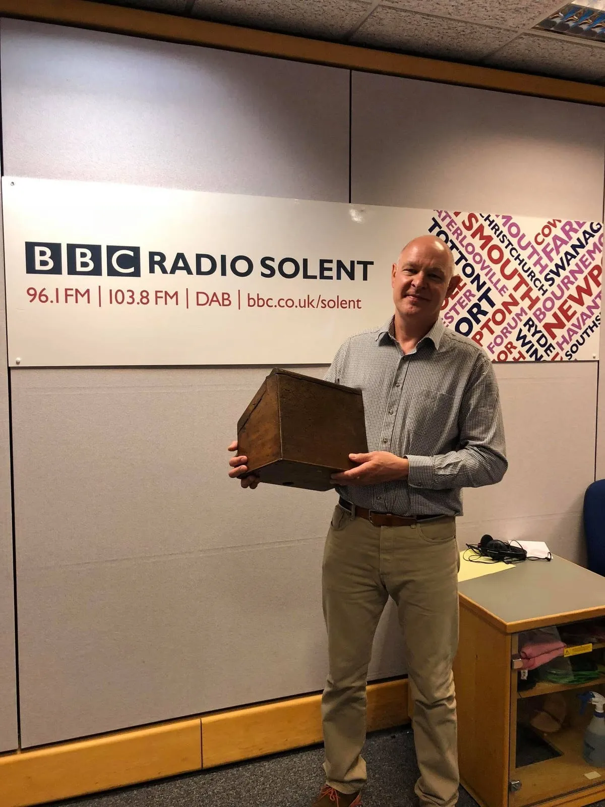 David holding an antique box in front of the BBC Radio Solent sign